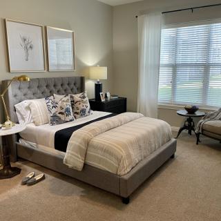 A beautifully decorated bedroom with a stylish bed, elegant furniture, and calming neutral tones.
