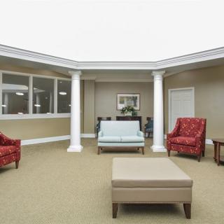 A spacious waiting room with comfortable seating and elegant pillars.