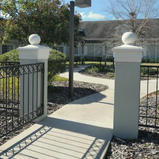 A gated pathway leading through a landscaped garden area.
