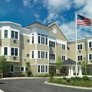 A modern residential building with an American flag in front.