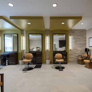 A modern salon interior featuring styling chairs and mirrors.