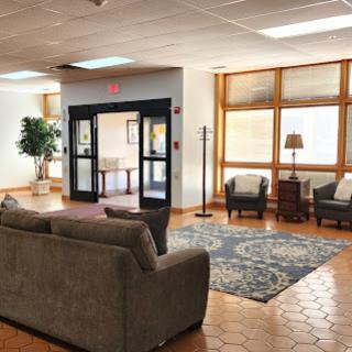 A cozy lobby area featuring comfortable seating, natural light, and decor.