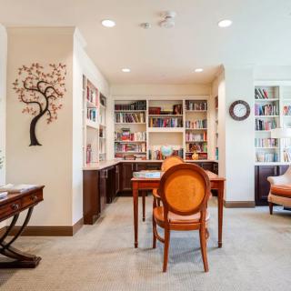 A cozy home office with bookshelves, a desk, and decorative elements.