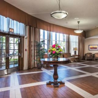 A spacious lobby area with elegant decor, featuring a central table adorned with a flower arrangement.