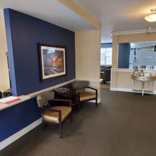 A cozy office lobby with seating and a painting on the wall.