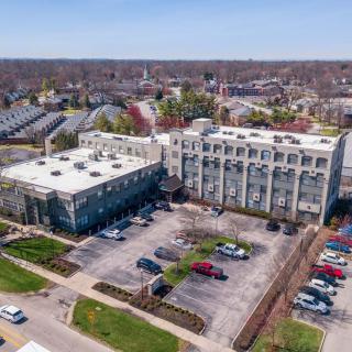 Aerial view of a building with an adjacent parking lot in an urban area.