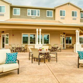 A spacious outdoor patio area with comfortable seating at the back of a residential home.