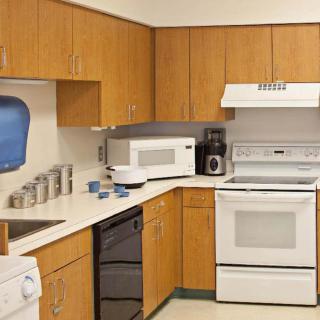 A modern kitchen featuring wooden cabinets and essential appliances.