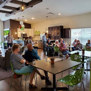 A group of people socializing in a cozy indoor setting, resembling a cafe or community space.