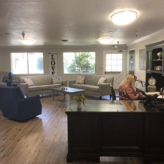 A spacious office area with a person working at a desk and comfortable seating.
