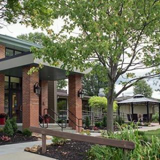 A modern building with an inviting entrance surrounded by trees and landscaping.