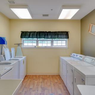 A bright and functional laundry room featuring washing machines, dryers, and ample natural light.