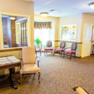 A bright and welcoming waiting room featuring several chairs and a window with natural light.