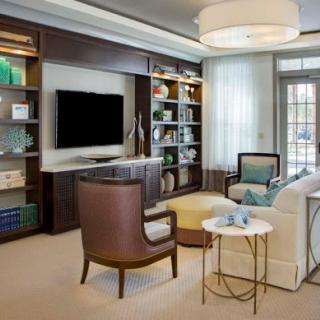 A cozy and modern living room featuring stylish furniture and a well-organized bookshelf.