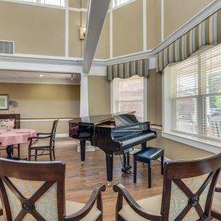 A cozy music room with a grand piano and seating area.