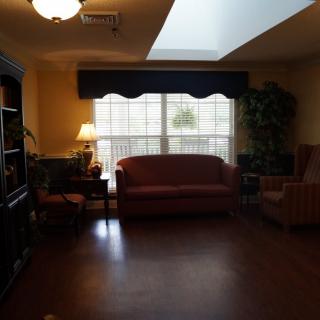 A cozy living room with a sofa and large window letting in natural light.