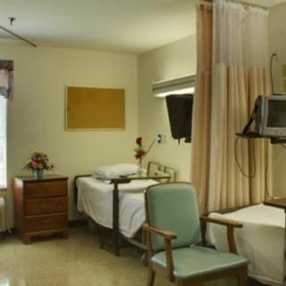 A hospital room with beds and medical equipment.
