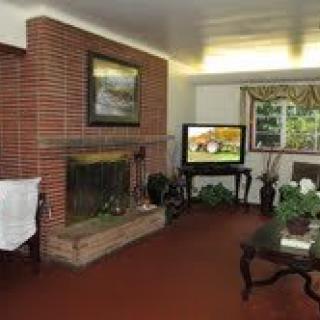 A cozy living room with a brick fireplace and television.