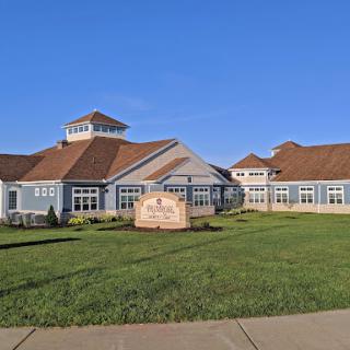 A beautifully designed building surrounded by green grass and clear blue skies.