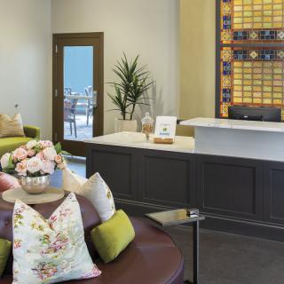 A modern reception area with comfortable seating, floral decorations, and a welcoming atmosphere.