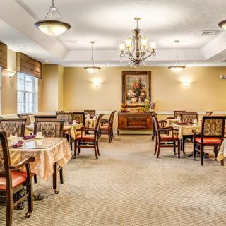 Elegant dining room with chandeliers and neatly arranged tables and chairs.
