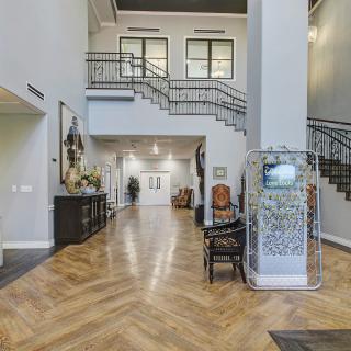 A luxurious interior space featuring a grand staircase and elegant wood flooring.