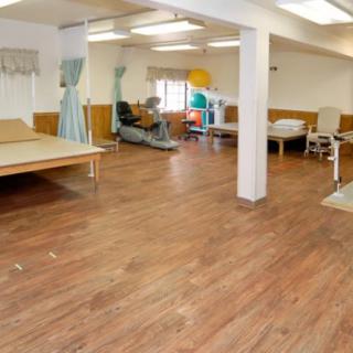 A spacious therapy room in a rehabilitation center equipped with medical and training equipment.