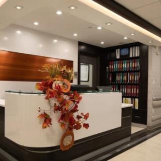 Modern office reception area with a decorated desk and bookshelves.