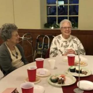 A group of elderly people enjoying a meal together at a social event.