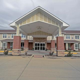 The modern brick and stone exterior of a large building with a prominent entrance.
