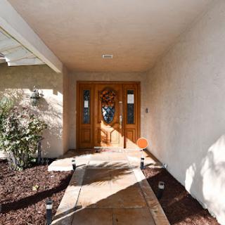Welcoming entrance to a beautiful home with a well-defined pathway and stylish door.