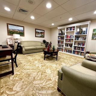 A cozy living room with sofas, a bookshelf, and elegant decor.