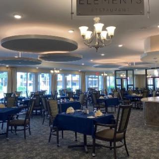 A spacious and elegantly decorated restaurant dining area with tables and chairs set for service.