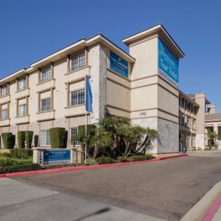 A modern hotel building with clear blue signage and landscaping.