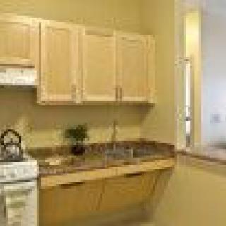 A small kitchen with light wooden cabinets and a stove.