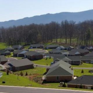 A suburban neighborhood with houses nestled near a mountain range.