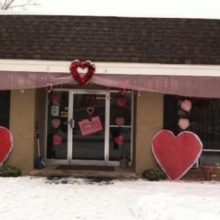 A house decorated with Valentine's Day hearts, surrounded by snow.