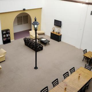An open interior space featuring a modern living area with sofas, a dining table, and decorative elements.
