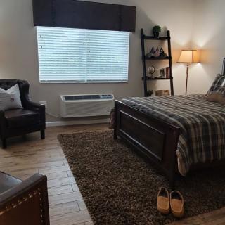 Cozy bedroom with a bed, armchair, and ambient lighting.