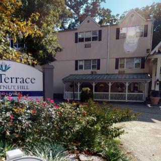 Exterior view of a residential building with a sign and garden.