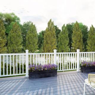 A scenic outdoor deck with white railings and a view of lush trees.