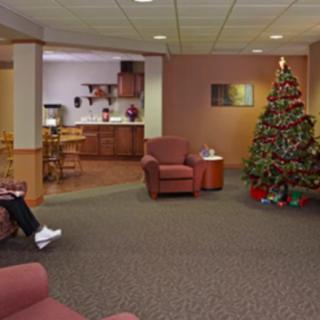 A cozy living room decorated for the holidays with a Christmas tree and comfortable seating.