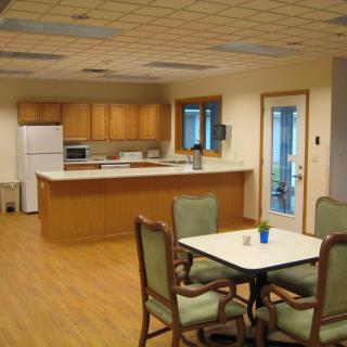 A cozy kitchen and dining area with wooden cabinets and a table set for four.