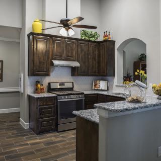 Modern kitchen interior with dark wood cabinets and granite countertops.