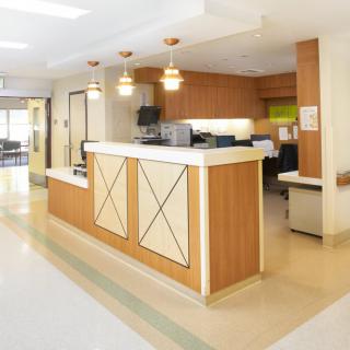 A hospital reception area with a central desk and bright lighting.