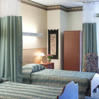 A hospital room with two beds separated by curtains.