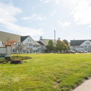 A sunny day view of a large building with a manicured lawn.