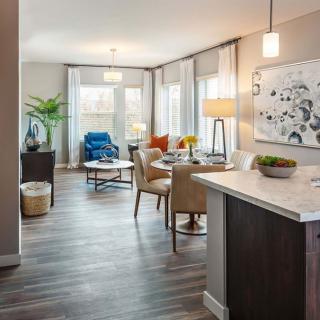 A modern open-concept living and dining area with stylish dcor and wood flooring.