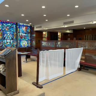 A serene interior view of a religious building featuring a vibrant stained glass window.