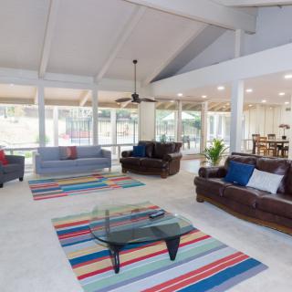 A spacious and modern living room with comfortable sofas and colorful rugs.